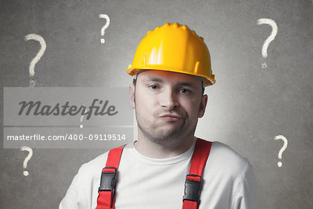 Confused young handyman with question marks
