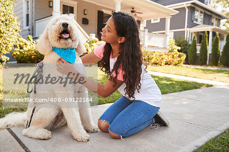 Girl Walking Dog Along Suburban Street