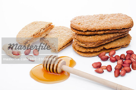 Healthy bio breakfast grain biscuits with honey and peanuts on white background