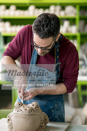 Ceramist Dressed in an Apron Sculpting Statue from Raw Clay in the Bright Ceramic Workshop.