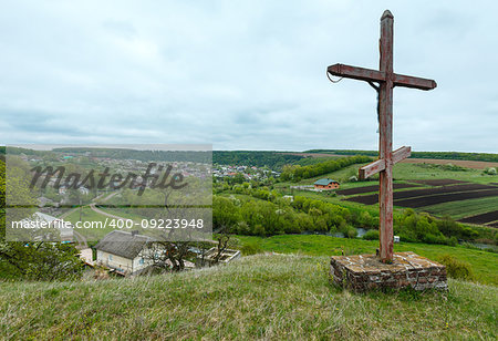 Wooden christianity religious cross near Rukomysh Cave temple and spring country fields and village, Buchach District, Ternopil Region, Ukraine.