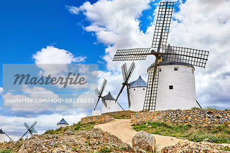 Wind mills at knolls at Consuegra, Toledo region, Castilla La Mancha, Spain. Route of Don Quixote with windmills. Summer landscape with blue sky and clouds.