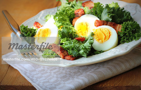 Fresh healthy salad with kale, chrispy bacon and egg .