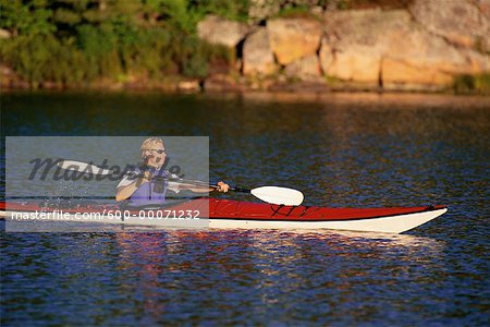 Man Kayaking on Lake, Haliburton, Ontario, Canada