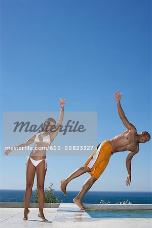 Woman Pushing Man Into Swimming Pool