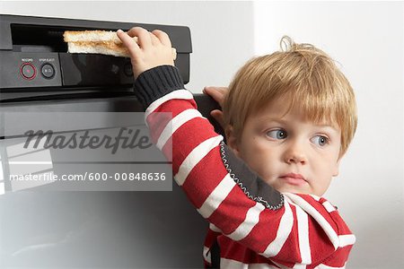 Boy Putting Sandwich in VCR
