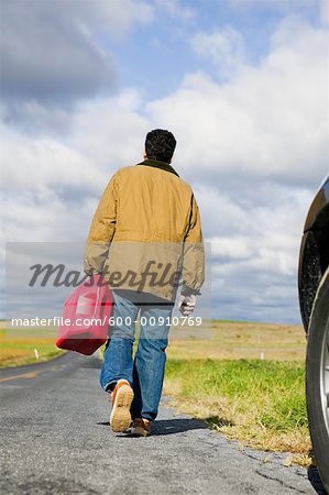 Man Walking on Road, Carrying Gas Can