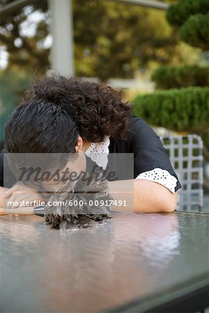 Maid Resting Head On Table Outdoors