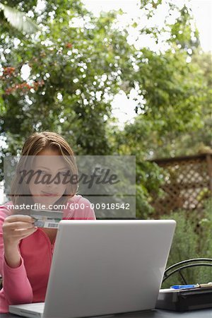 Woman With Credit Card Sitting Outside With Laptop Computer