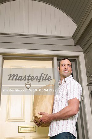 Man in Front of Home with Groceries