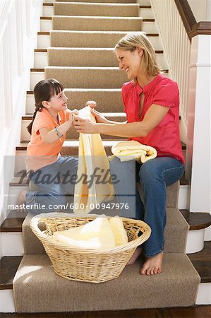 Mother and Daughter Folding Laundry on Stairs