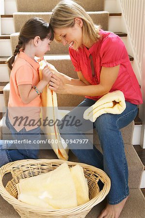 Mother and Daughter Folding Laundry on Stairs