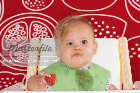 Baby Eating Strawberry in High Chair