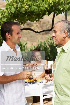 Father and Son Talking, with other Family Members in Background