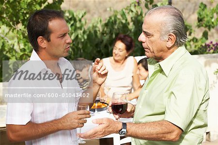 Father and Son Talking, with other Family Members in Background