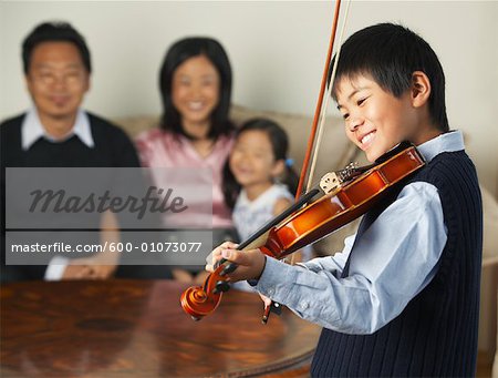 Family Watching Boy Play Violin