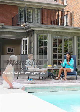 Women Lounging By Pool