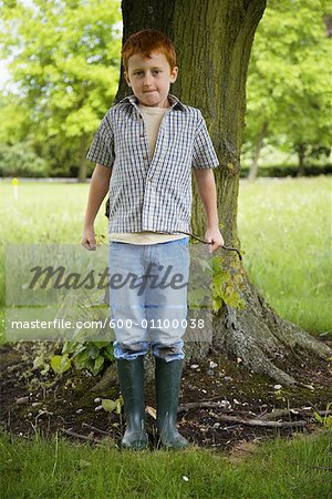 Boy Standing in Front of Tree