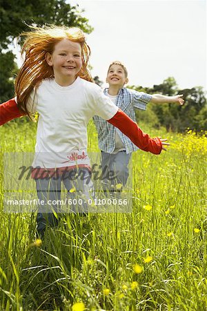 Girl and Boy Running in Field