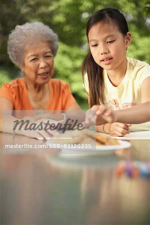 Grandmother and Granddaughter Sharing Plate of Cookies