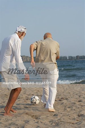 Men Playing Soccer on Beach