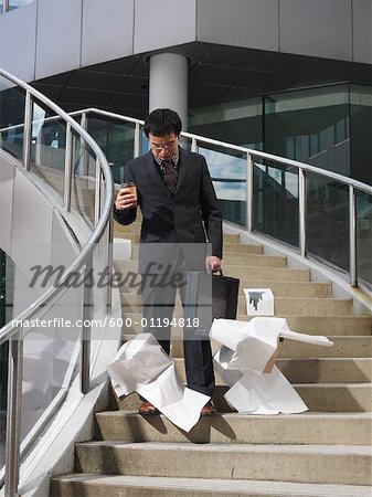 Businessman Dropping Papers on Staircase