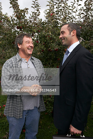 Businessman and Farmer in Orchard