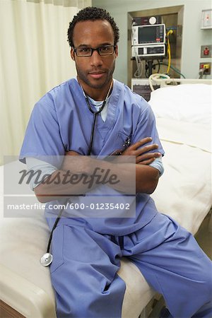 Doctor Sitting on Empty Bed