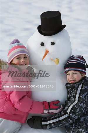 Brother and Sister Hugging Snowman