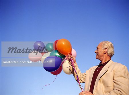 Man Holding Bunch of Balloons