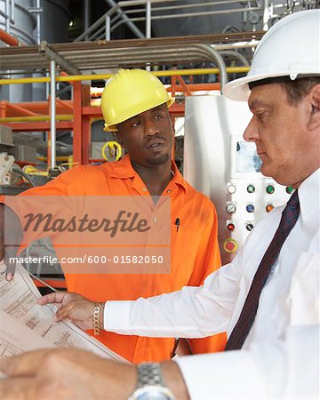 Workers Looking at Document in Water Treatment Plant