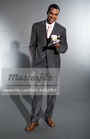 Businessman Holding a Newspaper and a Cup of Coffee