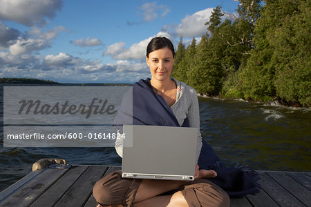 Woman Using Laptop on Dock