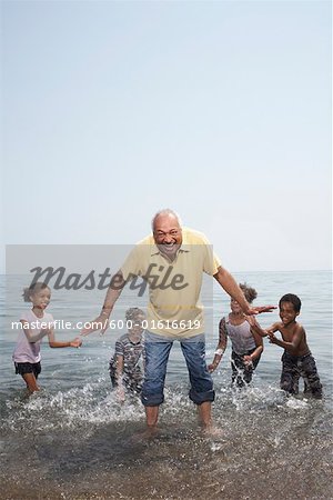 Man Being Splashed by Children in Lake