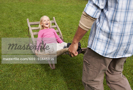 Father Pushing Daughter in Wheelbarrow