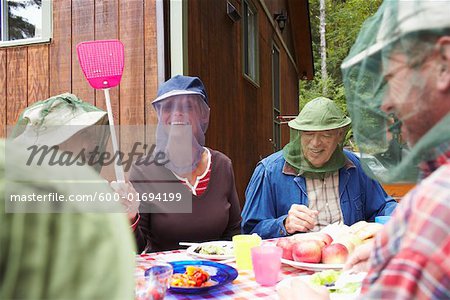 Family around Outdoor Table with Insect Masks