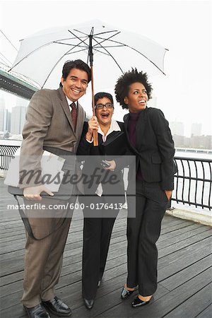 Business People Under Umbrella by East River, New York City, New York, USA