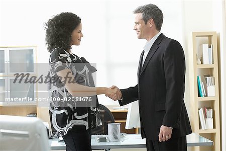 Businessman and Woman Shaking Hands in Office