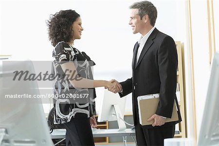Businessman and Woman Shaking Hands in Office