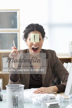 Businesswoman Sitting at Desk Writing