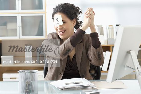 Businesswoman Sitting at Desk with Self Adhesive Note on Forehead
