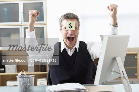 Businessman Sitting at Desk with Self Adhesive Note on Forehead