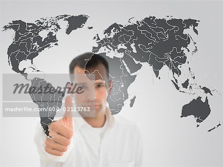 Portrait of Man Giving Thumbs Up in Front of World Map