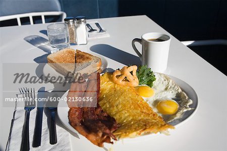 Plate of Bacon and Eggs on Table at Restaurant