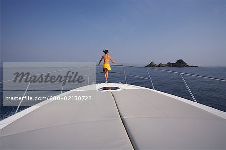 Woman Standing on Bow of Yacht, Girolata Marine Park, Corsica, France