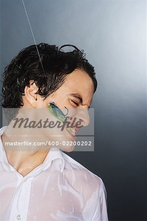 Fish Hook in Man's Mouth - Stock Photo - Masterfile - Premium
