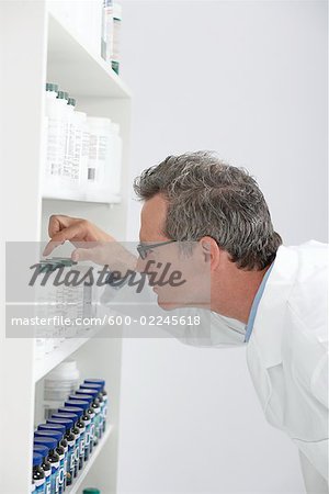 Pharmacist Looking at Pills on Shelf