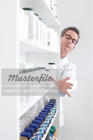 Pharmacist Taking Pills From Shelf