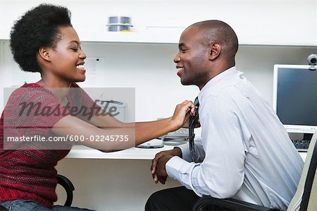 Woman Fixing Businessman's Tie