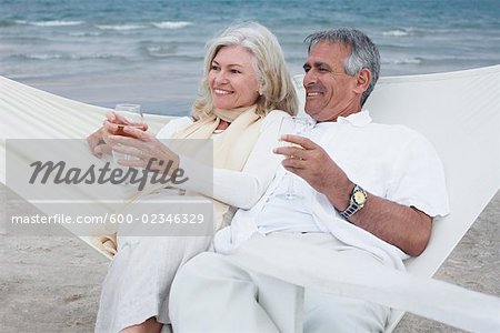 Couple Sitting on Hammock on Beach